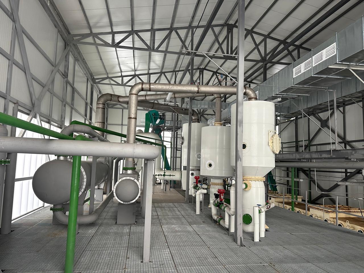 Технологічне обладнання з білими резервуарами та зеленими трубопроводами